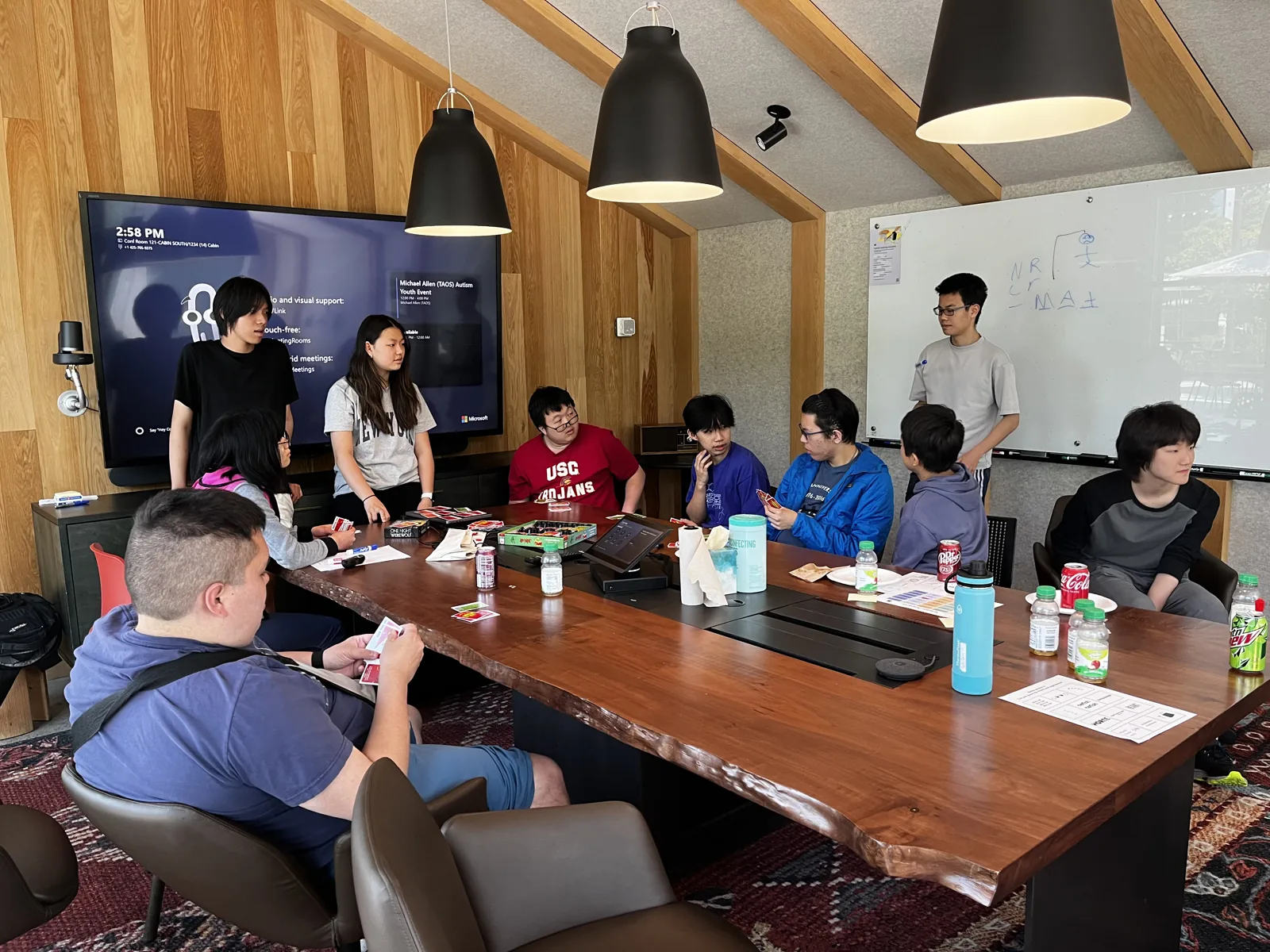 IncludEdU members and neurodivergent youth playing board games together around a table